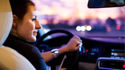 A woman sits at the wheel of a car